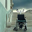 Leerer Rollstuhl vor Treppe
