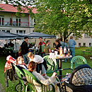 Menschen sitzen im grnen vor Haus